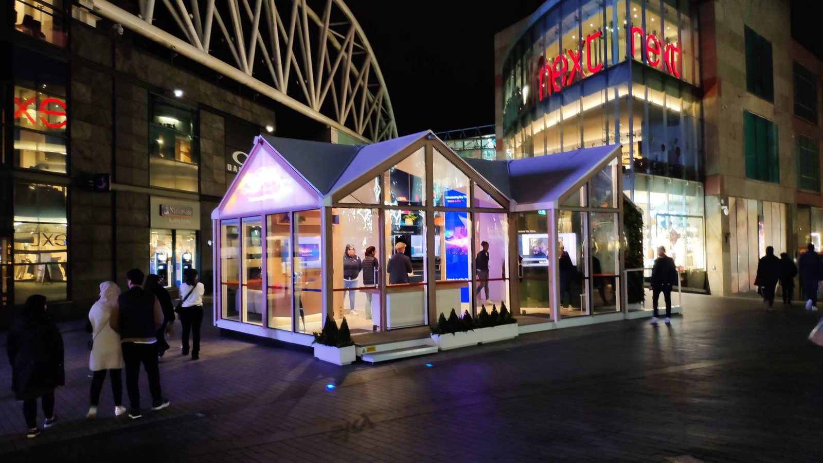 Illuminated pop-up retail pavilion at night